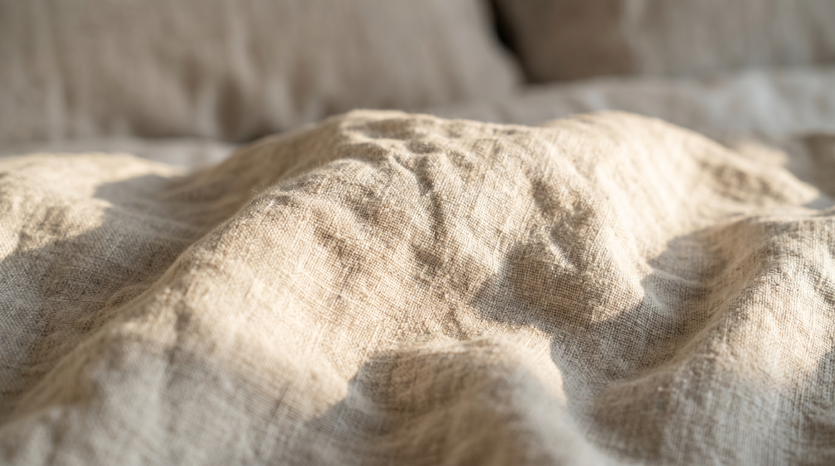 Close-up of natural linen bedding showing its soft, relaxed wrinkled texture