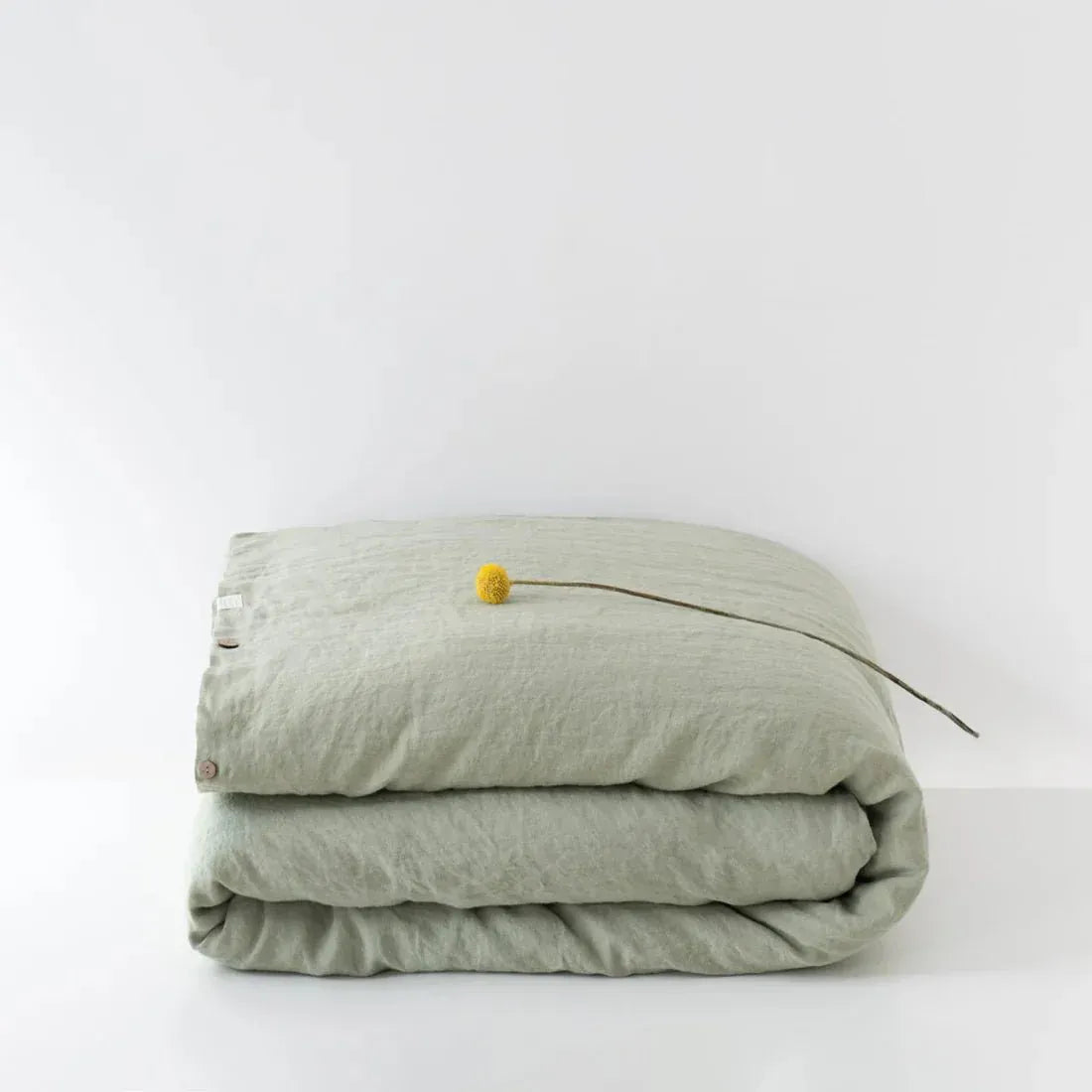 Sage green linen duvet cover on a bed